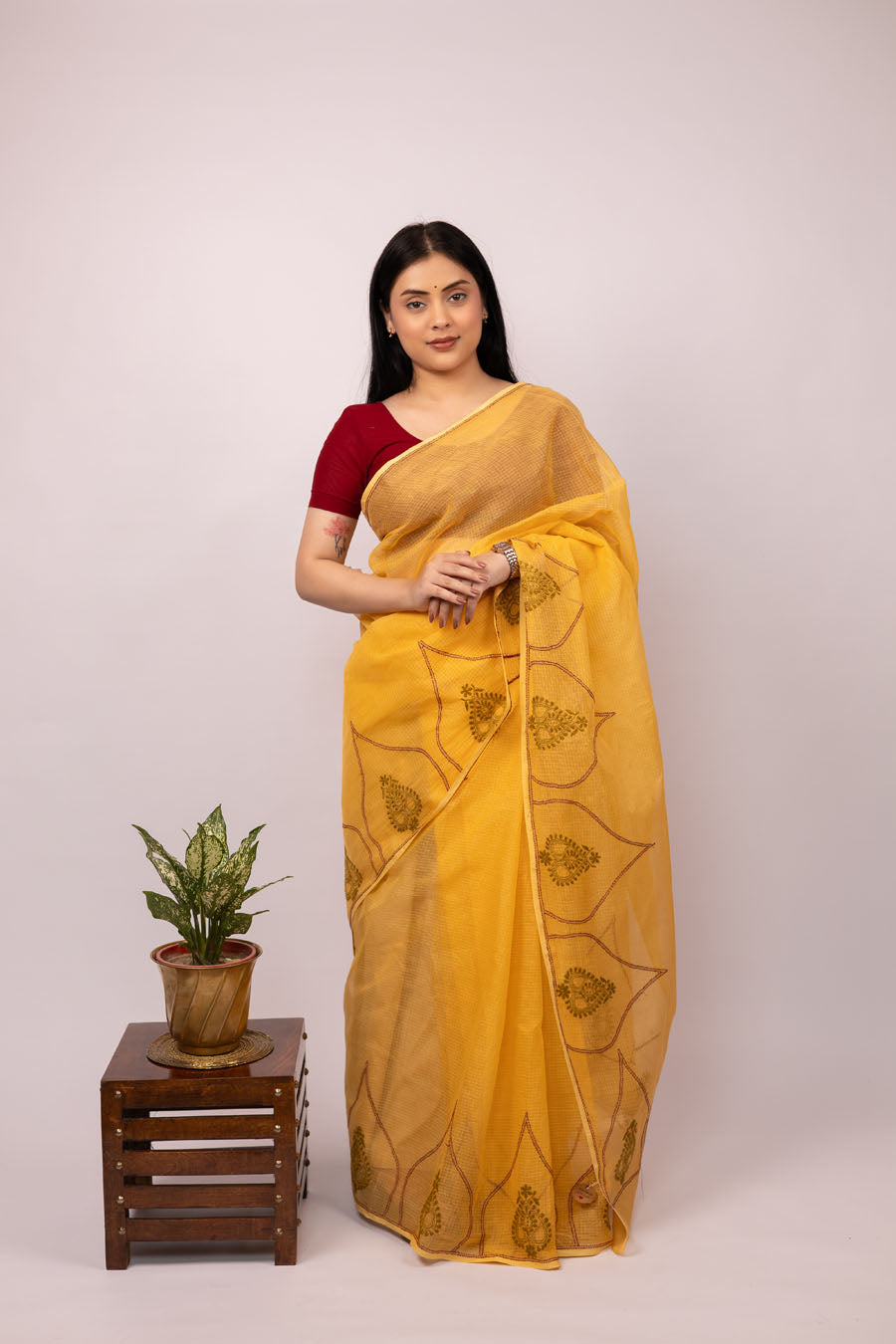 Lady wearing an Ochre Yellow Kotadoriya Cotton Saree with a beautiful design bel across border and pallu front view