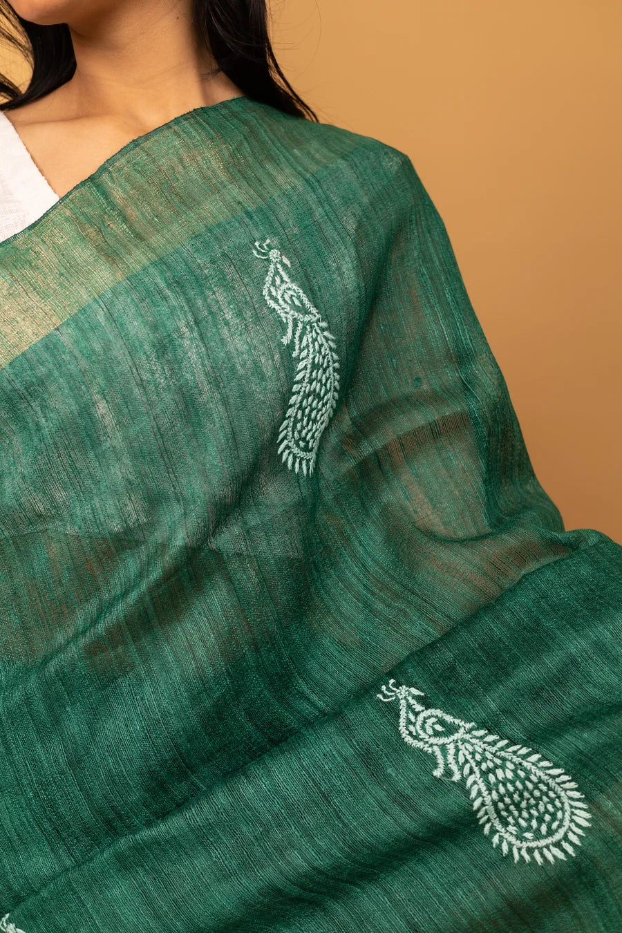 Green saree with white embroidery on a beige background