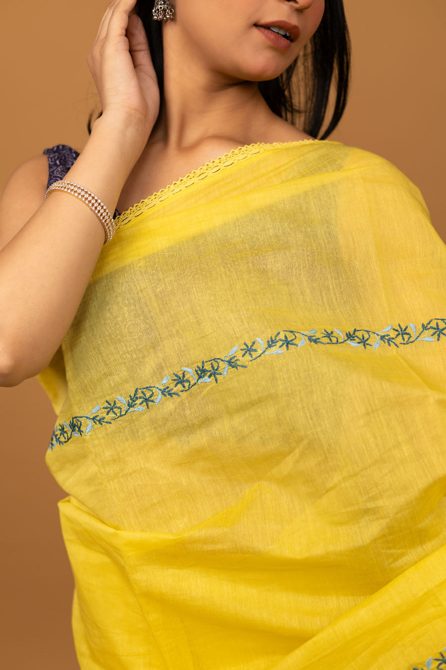 Detailed view of chikankari embroidered border on yellow saree