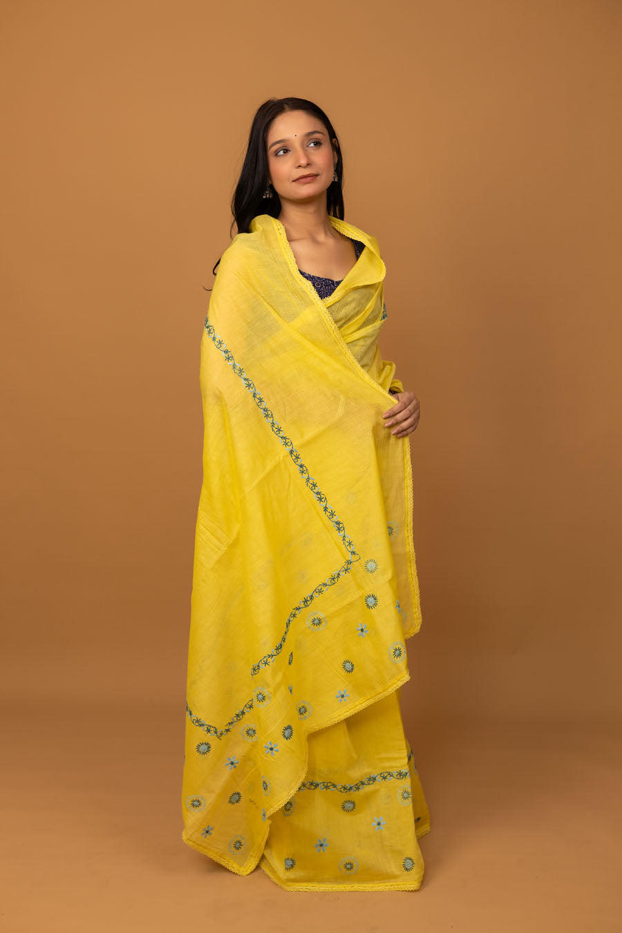 Side view of yellow embroidered chikankari saree with delicate blue floral motifs